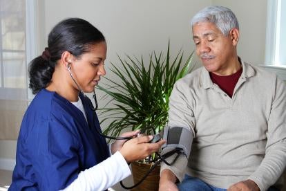 nursing home nurse checking a patient's blood pressure