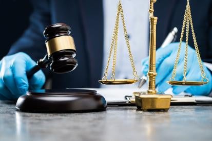 Gavel and scales of justice with gloves
