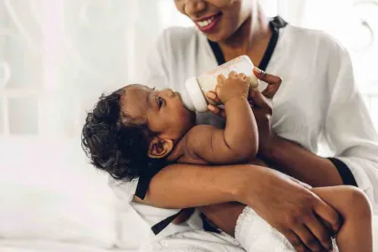 Baby with a bottle and a mom bonding