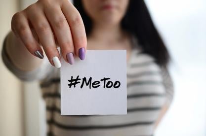 woman holding #MeToo post it note about sexual harassment