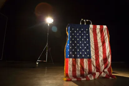 American flag, podium, microphone, spotlight