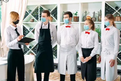 Workers in a restaurant complying with COVID Orders