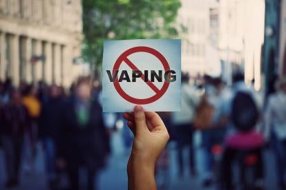 hand holding up a stop vaping sign during a protest
