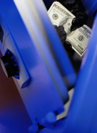 thief hands stealing money from a safe