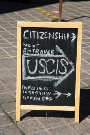 USCIS sidewalk sign for green card immigration processing 
