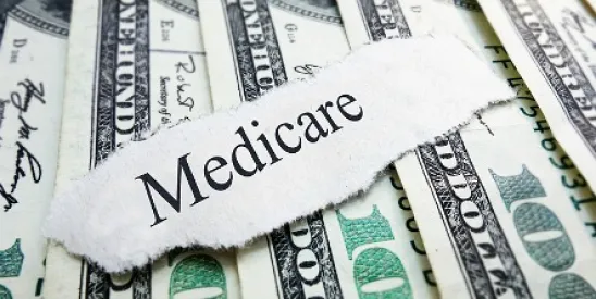 A torn off note stating Medicare placed on top of $100 bills